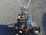 a small lawn mower on the ground in the middle of the street