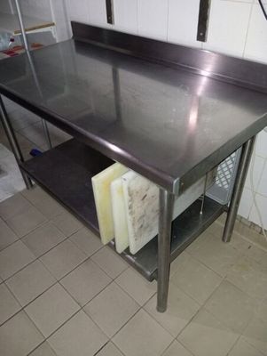 une table de travail en acier inoxydable avec une étagère en dessous