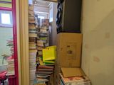 books stacked on top of each other in a narrow room