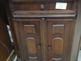 a wooden cabinet with a sign on it in a store