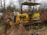 un bulldozer jaune garé au milieu d'un champ