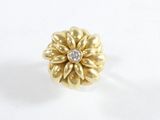 gros plan d'une bague en or avec un diamant au centre