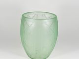 a green glass cup sitting on a white surface