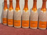 six bottles of champagne lined up in a row on a table