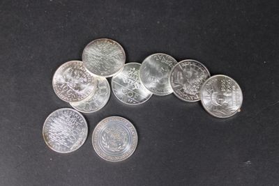 quelques pièces d'argent posées sur une surface noire, dont une petite partie
