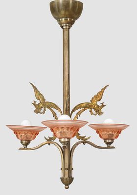 un lustre ancien en laiton avec des abat-jours en verre rose