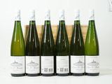 six bouteilles de vin sont alignées en rang devant une caisse en bois