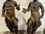 paire de statues en bronze représentant une femme et un homme, posées sur un socle en marbre