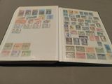 an open book with stamps on it sitting on a table