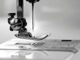 photographie en noir et blanc d'une machine à coudre posée sur une table