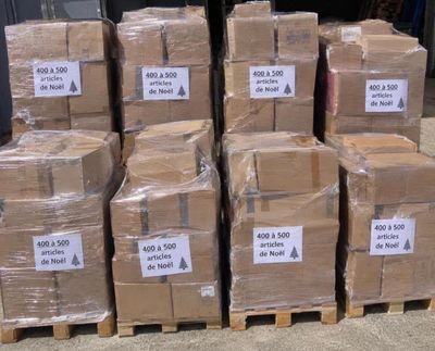 several stacks of cardboard boxes are stacked on pallets in a warehouse