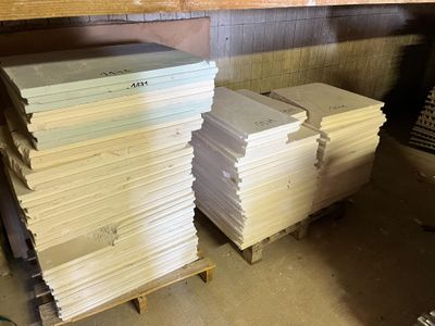 several stacks of paper are stacked on pallets in a warehouse