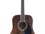 an acoustic guitar sitting on a stand against a white background