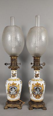 une paire de lampes en forme de vase, blanches et dorées, posées sur des socles, sur une surface grise