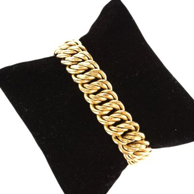 un gros plan d'un bracelet à chaîne en or sur un mannequin