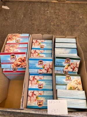 Plusieurs boîtes de nourriture pour bébé sont posées dans un carton posé par terre