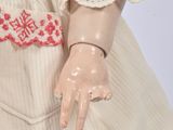 a doll that is wearing a dress and holding something in her hand