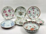several plates and bowls are sitting on a white surface