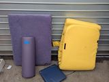 un sac à dos jaune, un sac violet et un téléphone portable par terre