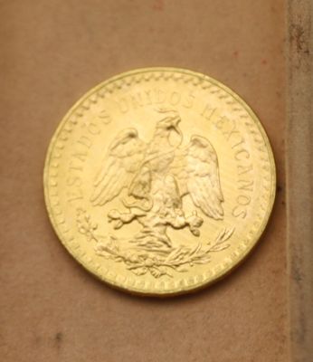 une pièce d'or posée sur une boîte en carton
