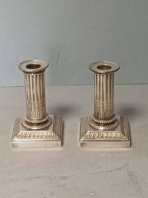 deux bougies en argent posées sur une table