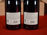 two bottles of wine sitting next to each other on a table