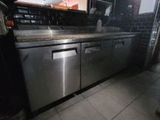 un homme debout dans une cuisine, avec un lave-vaisselle devant lui