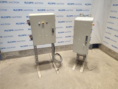 deux coffrets électriques placés devant un mur, avec un panneau derrière eux