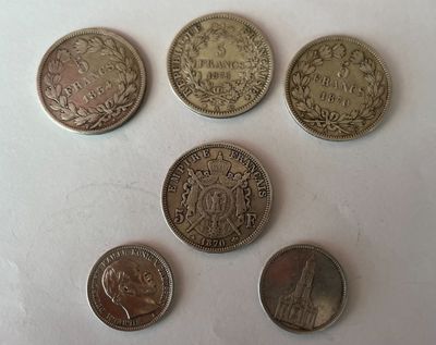 six pièces de monnaie britanniques différentes posées sur une surface blanche