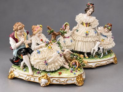 deux figurines représentant des enfants assis sur un banc avec un chien