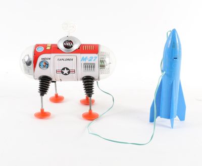 un petit robot jouet avec une fusée, posé par terre