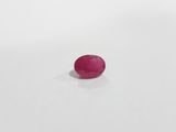 raspberry pink oval stone on a white surface