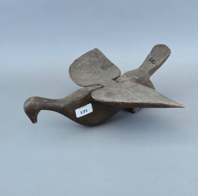 un vieil objet en métal sur lequel est représenté un oiseau