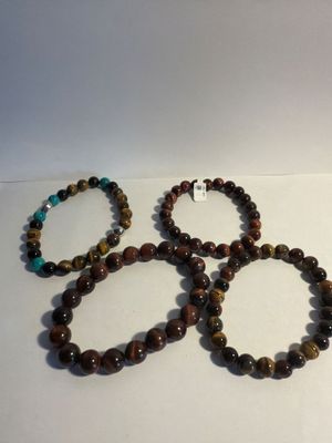 three bracelets with tiger ' s eye beads on a white surface