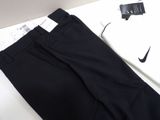 black pants and a white shirt are sitting on a white table