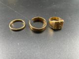three gold rings sitting on top of a table next to each other