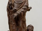 statue en bois représentant une femme tenant un enfant dans ses bras, posée sur une table