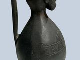an image of a bronze vase with a face on it