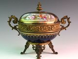a blue and gold bowl with a lid on a stand