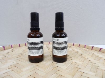 two bottles of liquid sitting on top of a woven basket