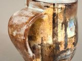 a brown and white vase sitting on a table