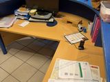 a desk with a computer and a lot of papers on it