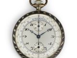 une montre de poche exposée sur une surface blanche