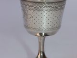 a silver cup sitting on top of a metal stand