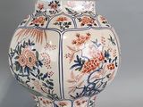 a large vase with a bird on top of it