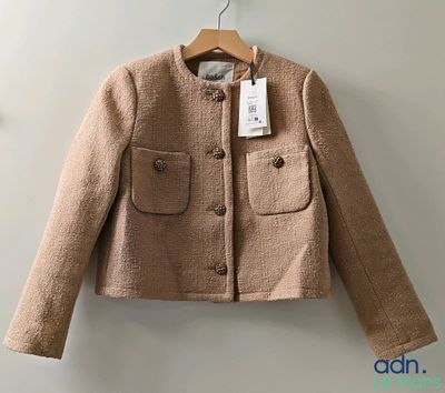 a close up of a jacket on a hanger on a wall
