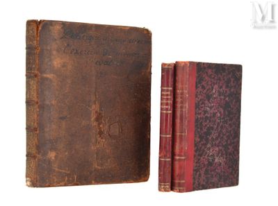 un vieux livre posé à côté d'un vieux livre sur une surface blanche