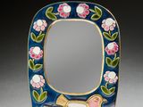 une image représentant un miroir orné d'un oiseau et de fleurs