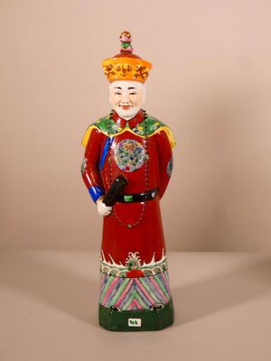 une figurine représentant un homme vêtu d'un costume rouge et d'un chapeau