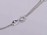 a close up of a silver chain with a heart on it